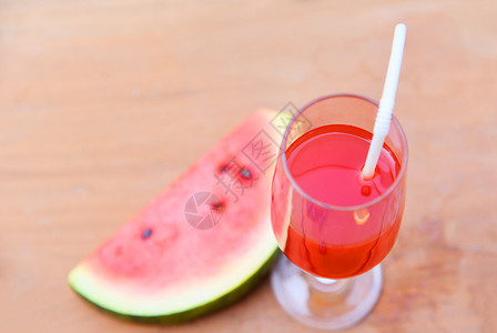 西瓜果汁玻璃上加西瓜果实夏天在木制背景上加西瓜水果图片