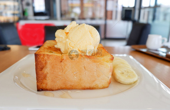 咖啡厅店的甜面包蜜蜂香草冰淇淋加奶油香蕉水果和白盘蜜蜂图片