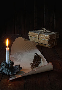 用蜡烛写作的羽毛在桌上滚动图片
