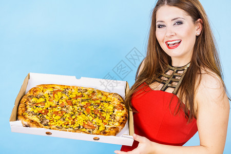 年轻人意大利烹饪概念年轻女在盒子里拿着热的新鲜大披萨在蓝色上美味快餐送货服务女在盒子里拿着大披萨图片