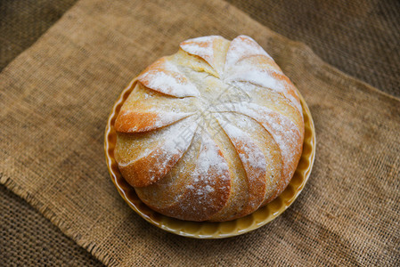 麻袋背景的新鲜面包盘自制早餐食品概念面包圆图片