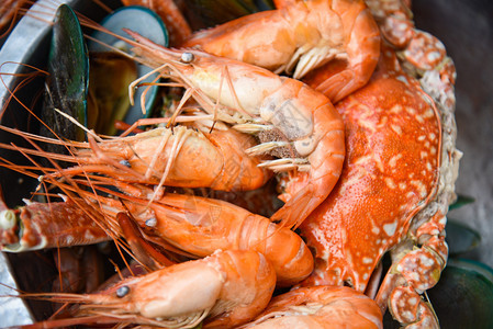 海食品板贝壳鱼和蒸虾贝在热锅中煮底有草药和香料背景图片