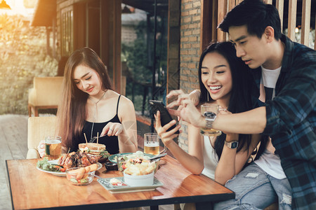 单身女人与餐厅吃饭拍照的情侣图片