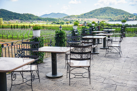 户外餐厅露台的桌椅和子观看自然农场和山地背景露台的餐桌图片
