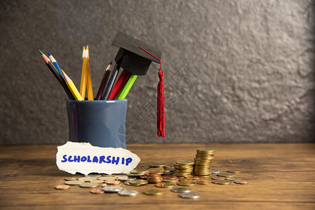 在黑背景奖学金的铅笔箱中背着钱币木桌对铅笔颜色加结的毕业上限然后回到学校教育概念图片