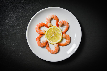 虾在暗底盘上装饰海鲜和柠檬图片