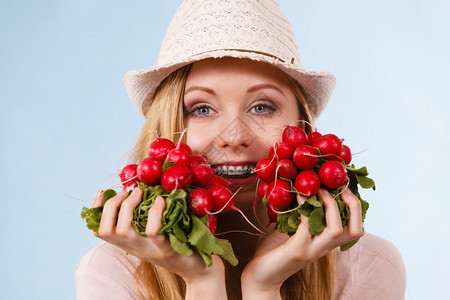 快乐的年轻少女准备过暑假穿着粉红色服装戴着美味萝卜的太阳帽图片