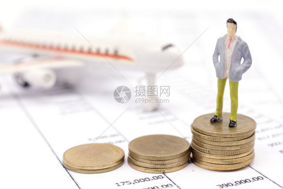 飞机模型旁边放着硬币和人偶图片