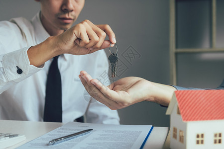 销售商房屋经纪人为新的房主提供办公钥匙图片