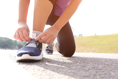 与跑鞋慢者医疗保健和福利概念捆绑在一起的活跃健康妇女图片