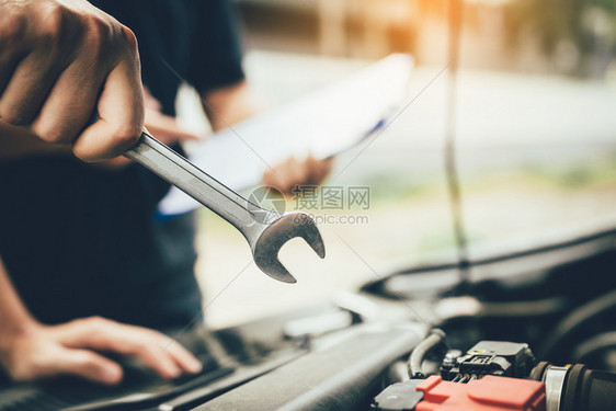 汽车修理工拿着扳手准备检查引擎图片