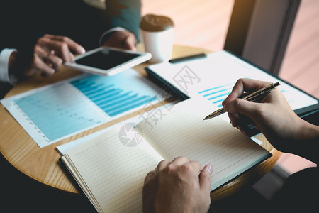 商业伙伴合作者使用平板块绘制公司财务报表告利润工作进展和办公室规划图片