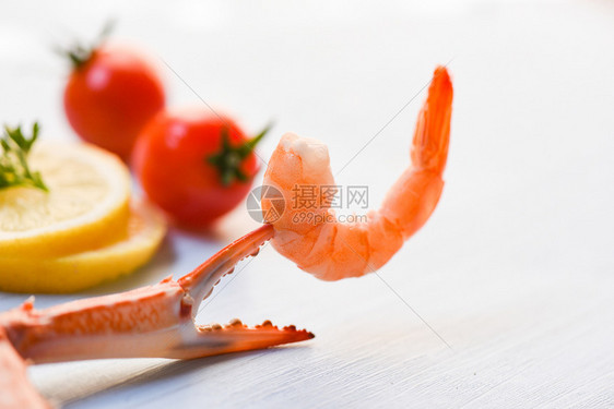 蟹爪上的虾餐桌背景的番茄柠檬装饰图片