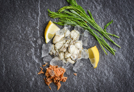 鲜生牡蛎在黑板和冰上供养在海产食品餐厅里用鲜牡蛎和蔬菜柠檬草药喂养牡蛎沙拉图片