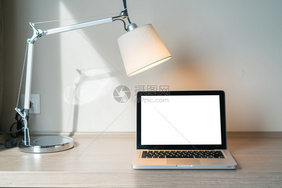 手持灯具的桌上手提电脑图片