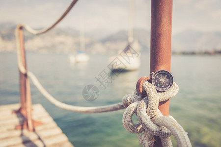 笼罩着在模糊背景中躺在帆绳上海洋和船图片