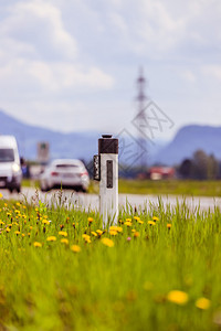 夏季田间沥青路的反射镜柱和汽车背景图片