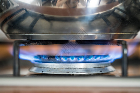 紧贴着一股蓝色气体火焰在厨房做一个水壶图片