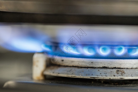 紧贴着一股蓝色气体火焰在厨房做一个水壶图片