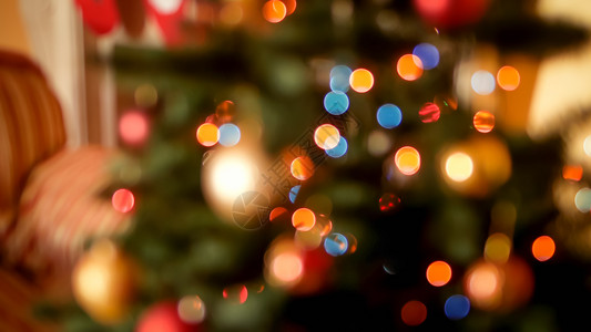 在客厅的圣诞树上闪耀着明亮的圣诞灯光和彩色长袍的画面摘要模糊冬季假日和庆祝活动的完美背景圣诞灯光的亮度和客厅圣诞树上的彩色长袍和背景图片