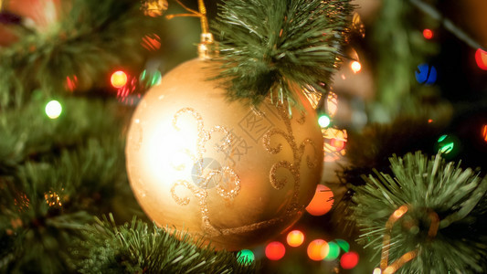 在圣诞树枝上挂着火花的金色黄近切抽象照片冬季假日和庆祝活动的完美背景圣诞树枝上挂着火花的金色黄近切抽象图像冬季假日和庆祝活动的完图片