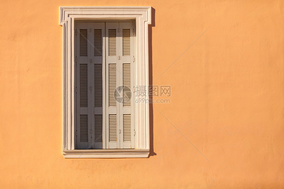 典型的地中海建筑白色窗口边界橙家庭墙上有百叶窗橙色家庭墙上有百叶窗图片