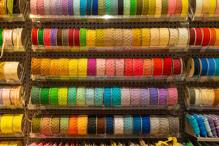 卷轴纹理素材纺织业购物商场零售店的书架上堆满了多彩的缝纫线在书架上的缝纫线背景