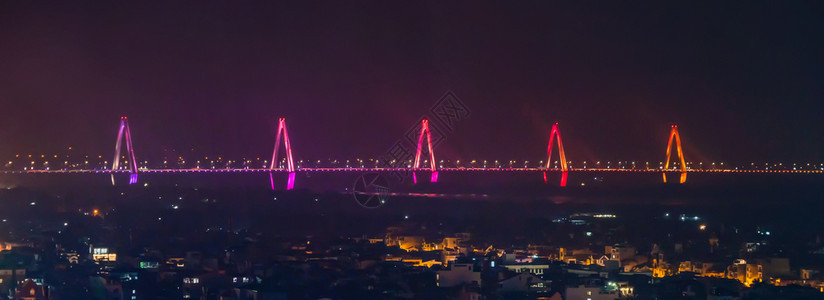 NhatTanBridge在城市有照明和河流在越南内市中心有停机桥交通概念晚上有建筑物图片