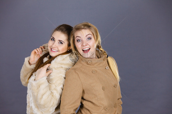 两名妇女穿着浅棕色大衣和毛皮外套冬季时装概念两名妇女穿着浅棕色大衣图片
