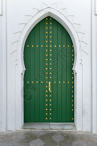 在摩洛哥阿西拉的梅迪纳用绿色漆木制门装饰金色品图片