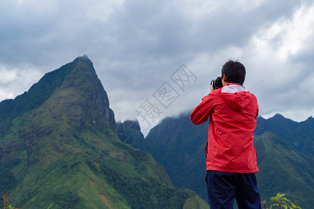 一名亚洲旅游男子在越南萨帕Sapa的旅游行和假期概念中夏季在Fansipan山上与稻田谷一起观望图片