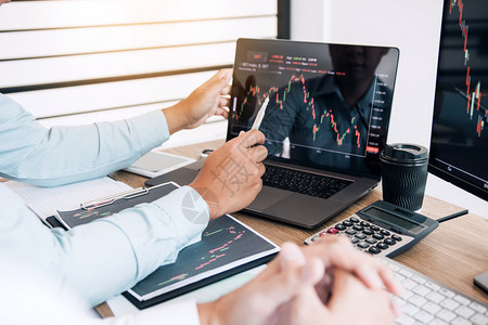 两个伙伴投资者讨论共同合作正在分析办公司计算机屏幕上的股票图表图片