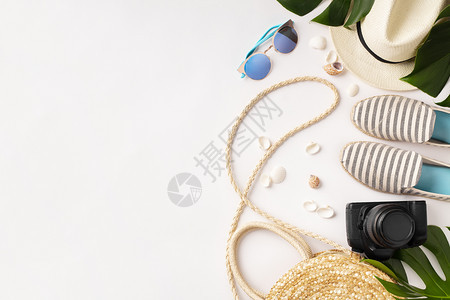 花样多彩的夏季女时装平板饰草帽照相机袋子夏鞋太阳镜贝壳和热带叶子白色背景顶层夏季时装假日概念文字空间图片