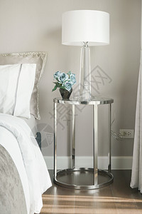 玻璃顶上不锈钢板边床桌旁的白遮光灯和蓝色玫瑰图片