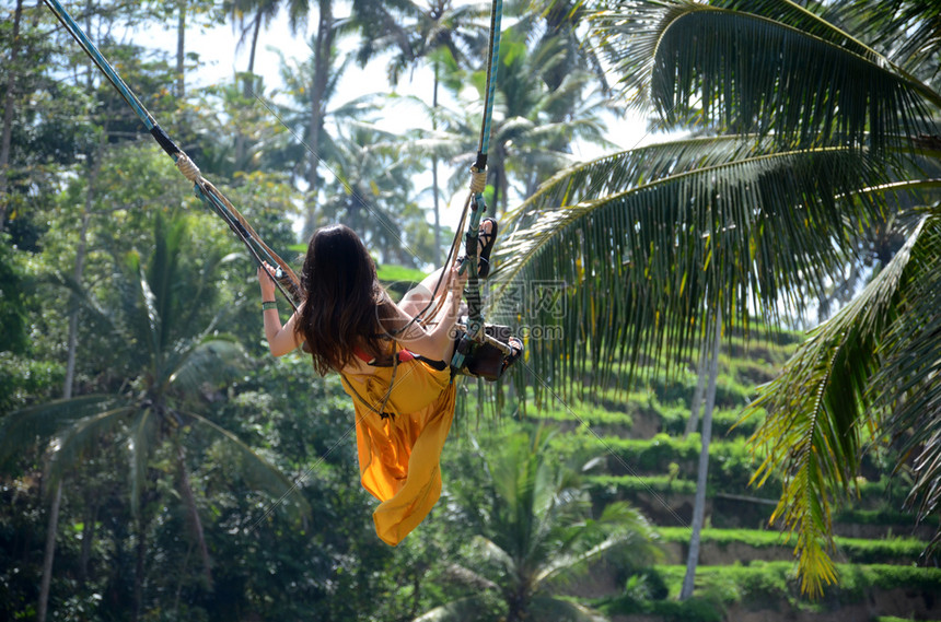 在印度尼西亚巴厘岛丛林雨中摇摆的年轻妇女图片