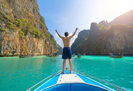 一名亚洲男子旅游者在暑假行期间在普吉岛的克拉比PhuketIsland夏季乘游假旅行蓝绿的海水坐船在克拉比Krabi俯冲或潜水图片