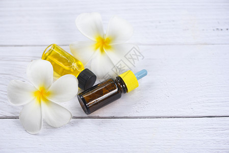 梅瓶Aroma治疗草药油瓶芳香白花弗朗吉帕尼普卢梅里安最佳视图木桌和有机最低限量剂上天然的必需油背景