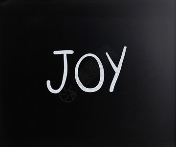欢乐这个词用黑板上的白粉笔手写图片