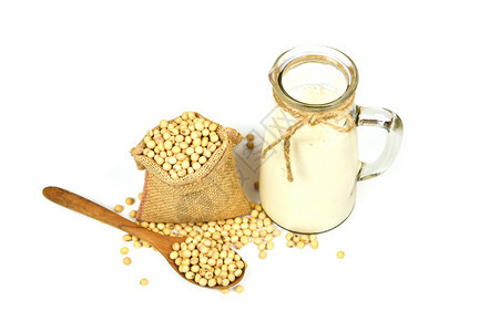 用木制勺子上的豆和在白底玻璃罐中的豆奶隔绝麻袋中用木制勺子上的豆和干用于健康饮食和天然豆蛋白图片