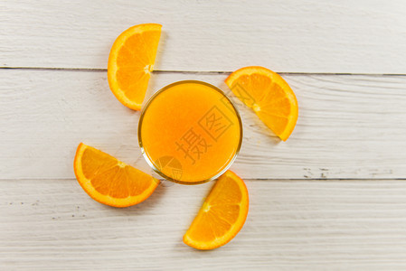 玻璃中的橙汁和木桌上新鲜橙子水果片图片