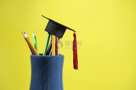 在黄色背景铅笔箱中颜色的毕业上限图片