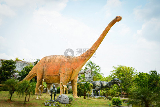 泰国KhonKaen2018年5月3日恐龙公园棕榈树花中不同物种恐龙雕像图片