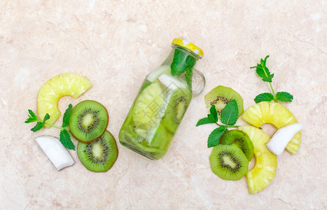 新鲜凉爽的kiwi和菠萝薄荷水脱毒饮料玻璃罐中的柠檬水图片
