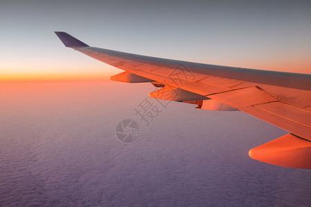 日落时飞机飞行的窗口视图图片