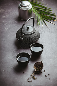 传统亚洲茶叶仪式安排铁茶壶杯干叶姜树和热带叶等紫混凝土背景顶层视图复制空间图片