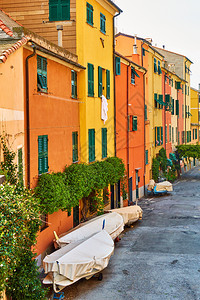 意大利热那亚Boccadasse区有多彩黄色和橙房屋的街道意大利Boccadasse区有多彩黄色和橙房屋停靠渔船图片