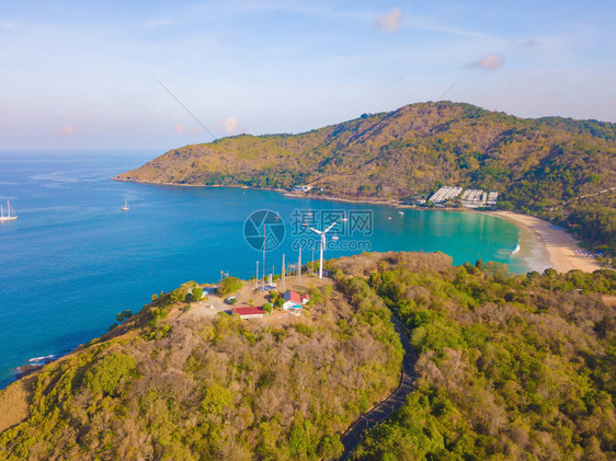 夏季在泰国普吉岛旅行时在Patong海滩看到一个风轮机上有蓝色绿宝石海水热带绿林树和安达曼海还有自然背景图片