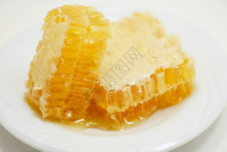 白色盘子上黄甜蜂窝切片天然健康食品图片