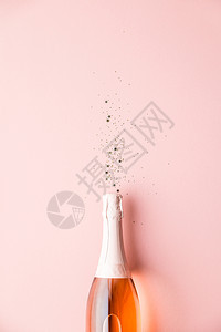纯洁的庆祝仪式香槟酒瓶有金派对的流水者粉红背景最顶端的色粉红背的图片