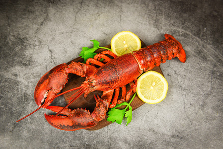 红龙虾有蔬菜和柠檬木板黑背景顶视龙虾晚餐图片